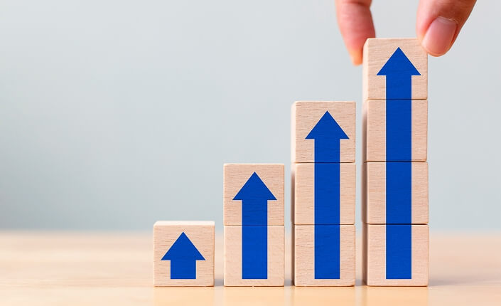 Cubos de madera con flechas azules pintadas apuntando hacia arriba