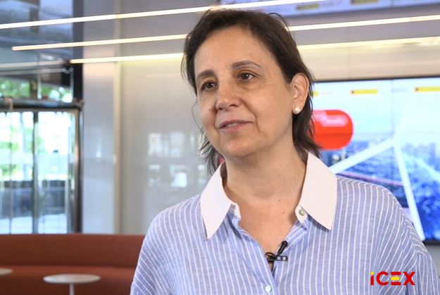 Mujer de pelo corto moreno con camisa de rayas azules y blancas
