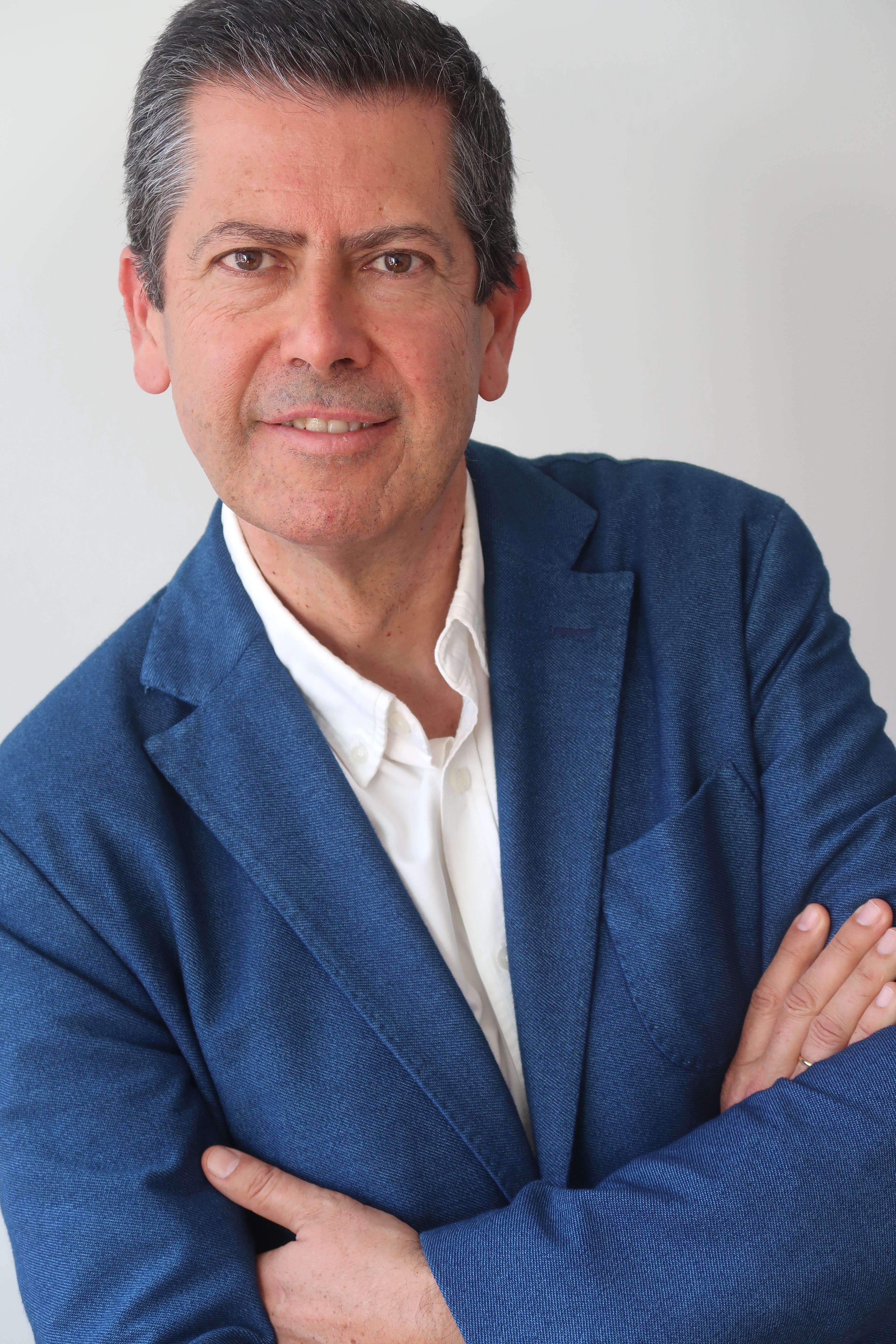 persona con chaqueta azul y camisa blanca y brazos cruzados