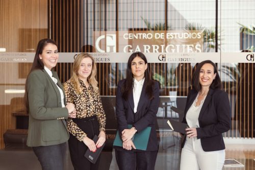 cuatro personas delante de un letrero que pone Centro de estudios Garrigues