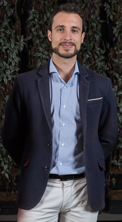 imagen de una persona con barba y chaqueta azul con los brazos cruzados en la espalda