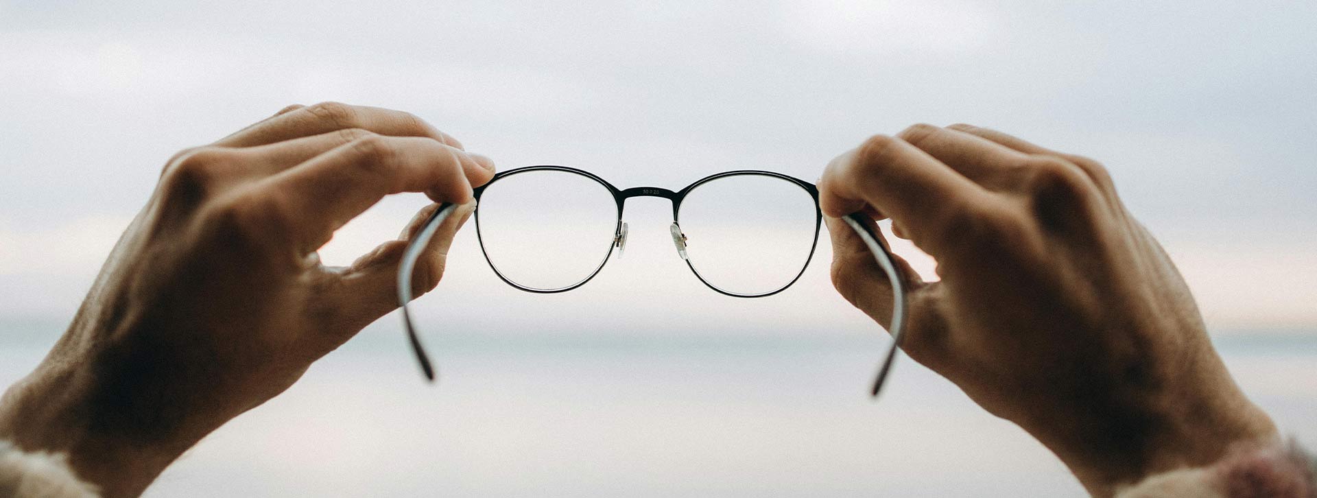 manos sujetando unas gafas para código ético
