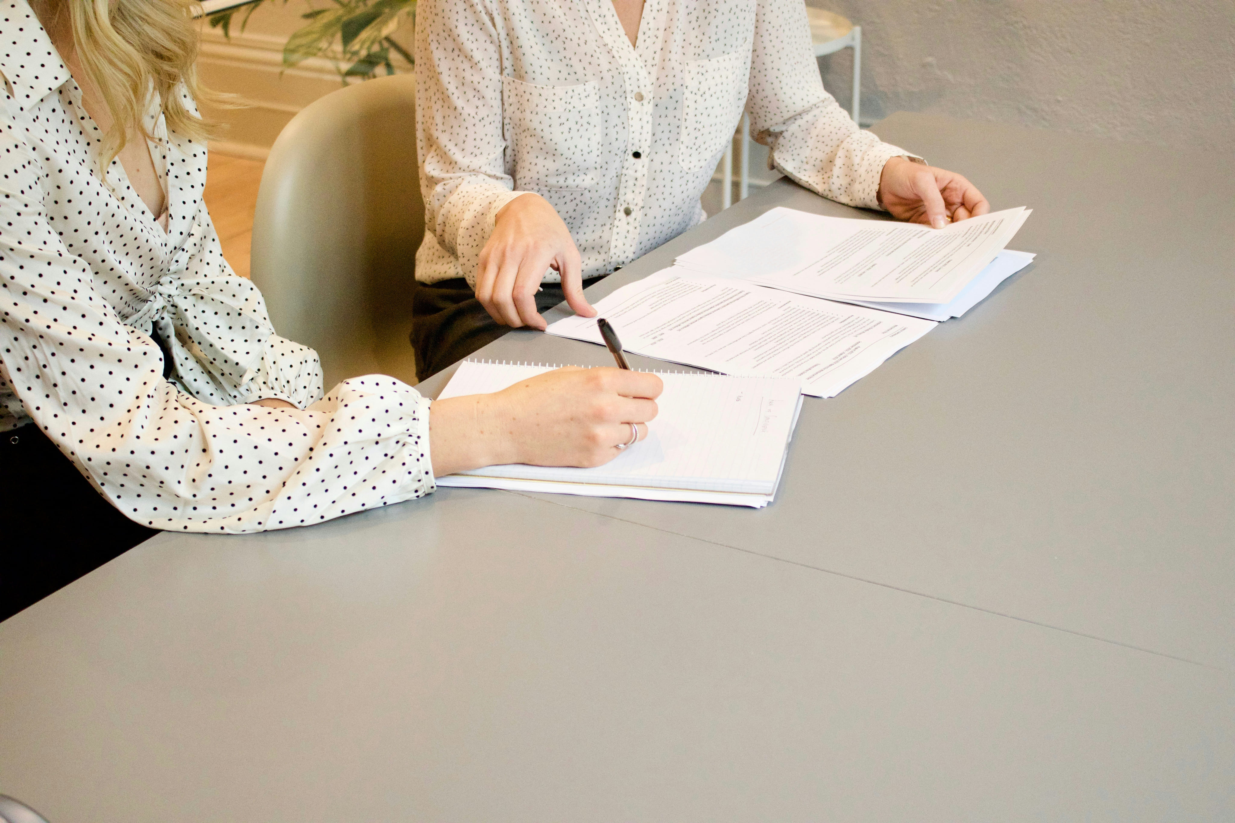 Mujer escribiendo en un cuaderno sobre un escritorio