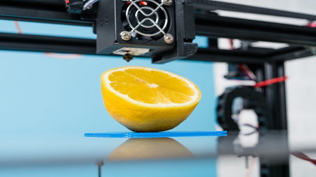 Ripe slice of yellow lemon citrus fruit . 3d printer of the device during the processe.