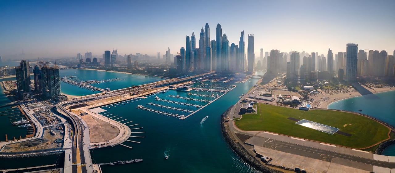 Panoramic view of Dubai Marina skyscrapers and JBR beacg with luxury buildings and resorts in one of the United Arab Emirates travel spots and resorts in Dubai aerial view