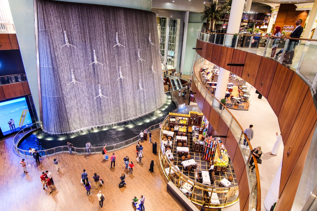 Dubai, UAE - March, 2019: A fountain or waterfall with  Silver Human Diver Sculpture figures inside Dubai Mall 