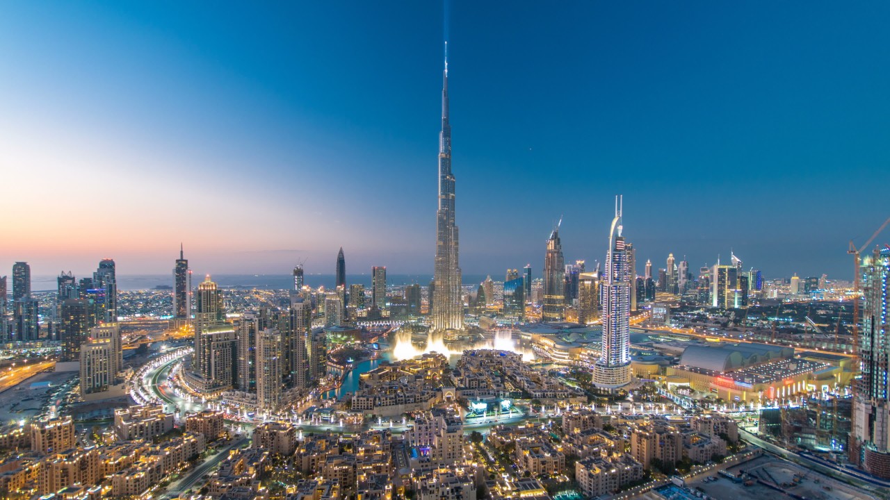 Dubai Downtown day to night transition timelapse with Burj Khalifa and other towers view from the top before new year celebration in Dubai, United Arab Emirates. Lights turning on.