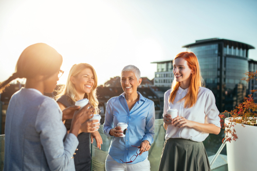 cuatro mujeres de negocios tomando café fuera de la oficina