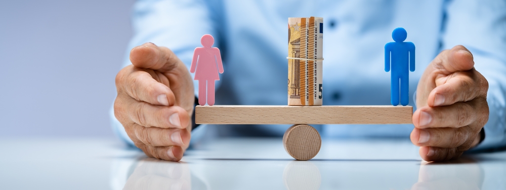 Balancín sobre el que un hombre y una mujer mantienen equilibrio salarial