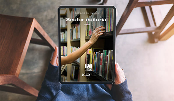 Una persona sentada visualiza en una tablet la portada del calendario ICEX para el sector editorial.