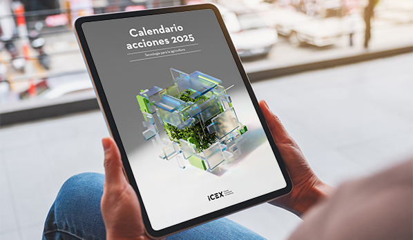 Una persona sujeta con las dos manos una tablet en la que visualiza la portada del calendario ICEX de actividades para el sector agritech