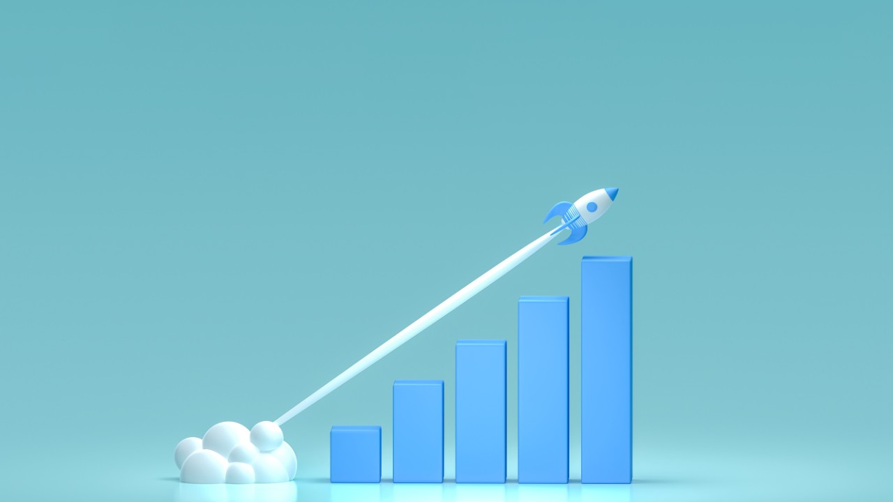 Un cohete despega y deja una estela de humo con trayectoria diagonal por encima de un gráfico de barras azules