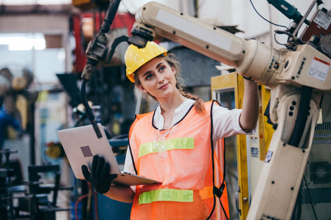 Ingeniera industrial trabajando con un robot          