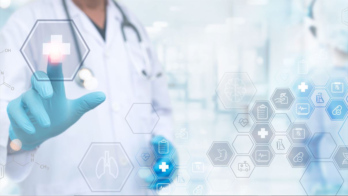 Un doctor con bata blanca y guantes azules toca un símbolo de una cruz blanca. Esta imagen simboliza la salud digital. En este artículo te explicamos los beneficios que aportan la inteligencia artificial y la digitalización al sector sanitario