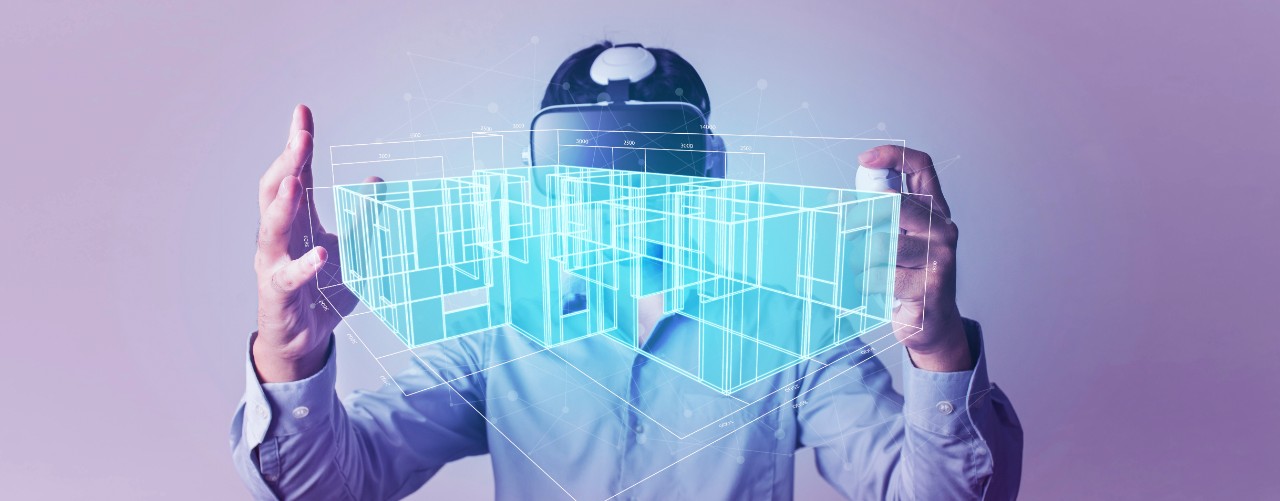 Una persona con unas gafas de realidad virtual observa un plano de una casa en un holograma