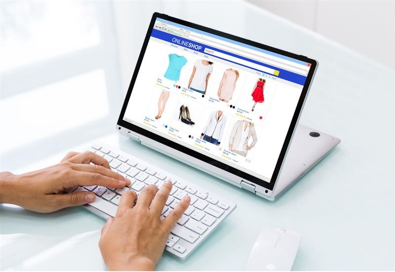 Una persona teclea en un ordenador portátil y consulta una tienda online