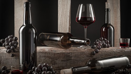 Botellas de vino español, junto a algunos vasos en un organizadas en un bodegón, colocado sobre unas estructuras de madera