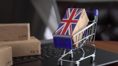 Carrito de la compra con una caja de mercancías con la bandera de Reino Unido.