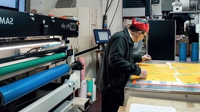 Un trabajador de Flexomed trabaja en la elaboración de un cartel