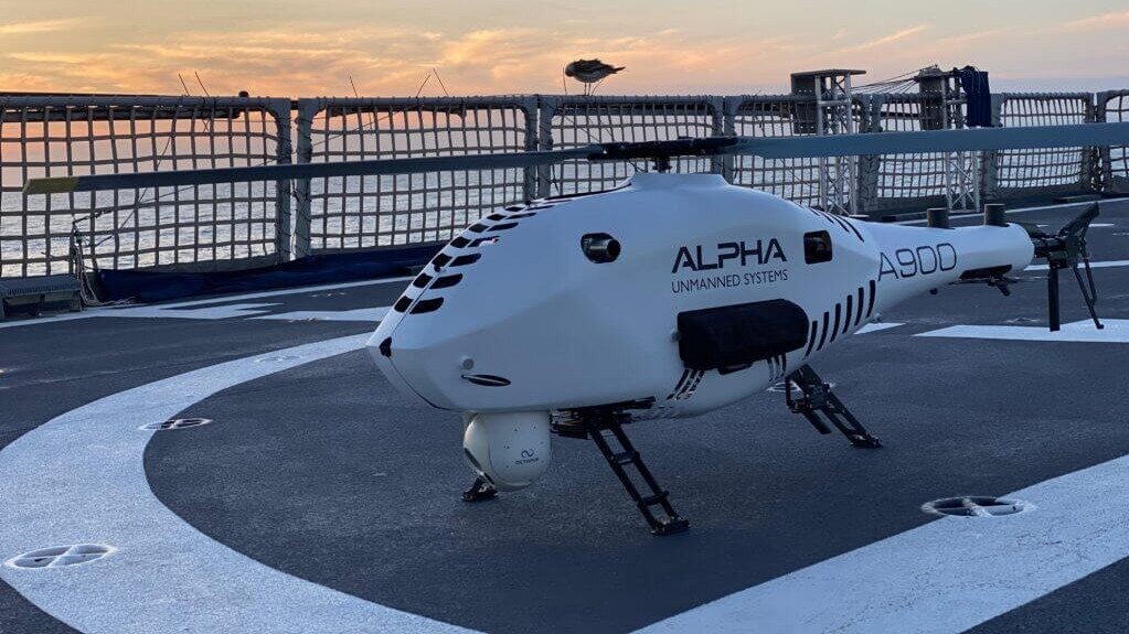 Un dron blanco con forma de helicóptero se encuentra en una pista de lanzamiento