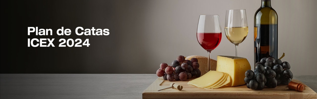 bodegón con dos copas de vino, una botella, queso y uvas sobre una tabla
