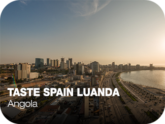 Taste Spain Luanda. Angola. A la derecha un skyline de edificios de viviendas y grandes edificios de oficinas. A la derecha una carretera, un puerto y el mar