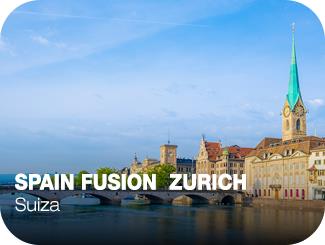 Spain Fusion Zurich. Suiza. Puente de piedra sobre un río, y a su derecha, unas casas de fachada clásica y una catedral.
